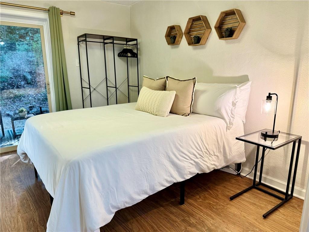 250 Little Street, Unit D107 Athens, GA 30605 - Photo 8 of 20 a bedroom with a bed and wooden floor