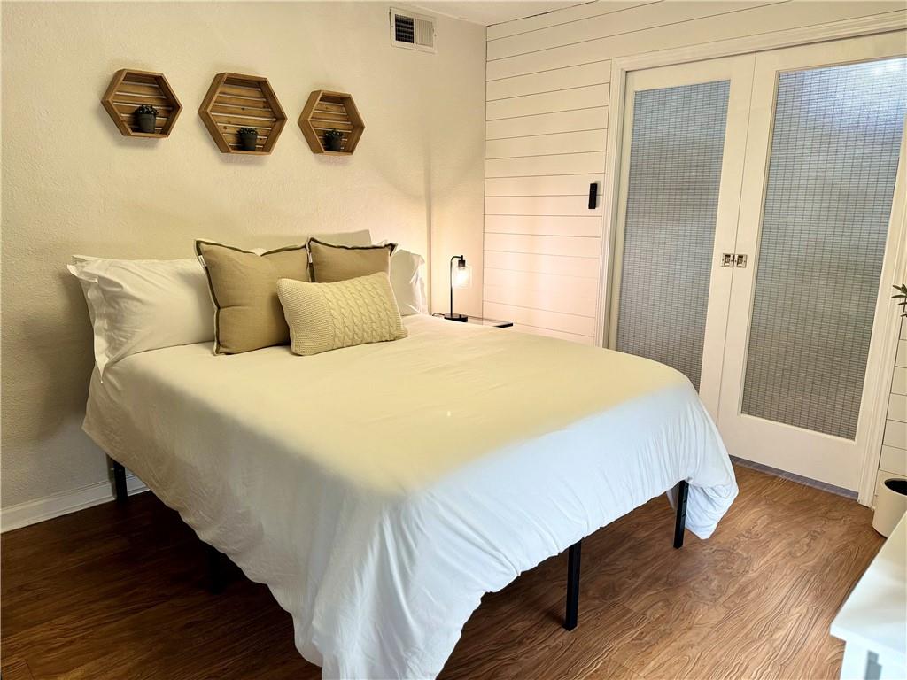 250 Little Street, Unit D107 Athens, GA 30605 - Photo 9 of 20 a bedroom with a bed and wooden floor