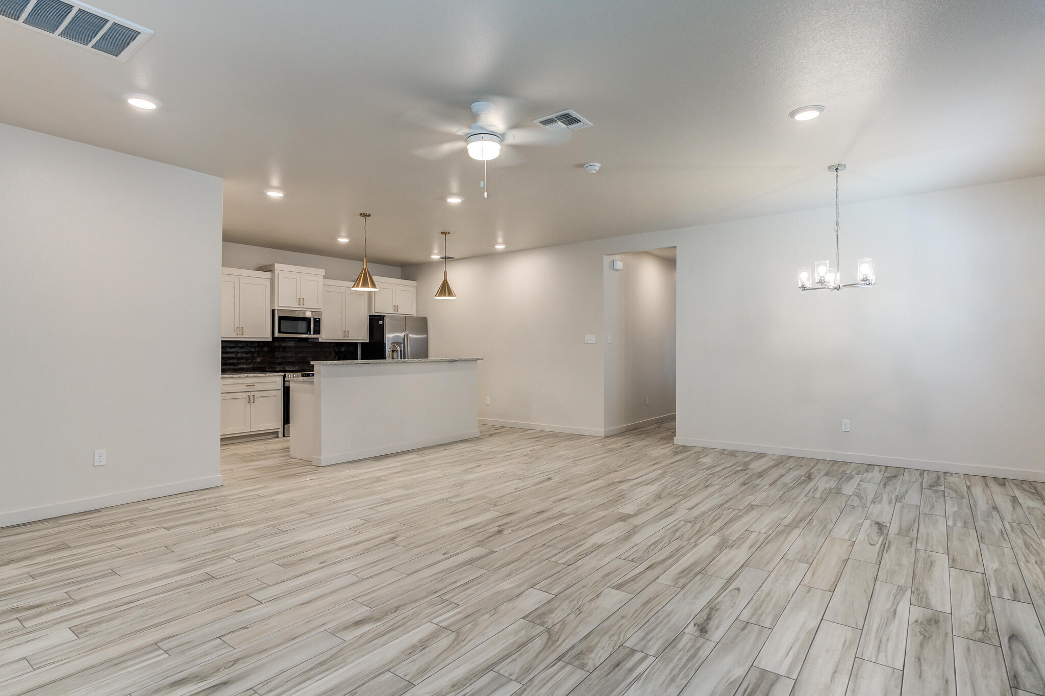 1119 North 7th Street Wolfforth, TX 79382 - Photo 3 of 25 a view of a kitchen with a sink and wooden floor