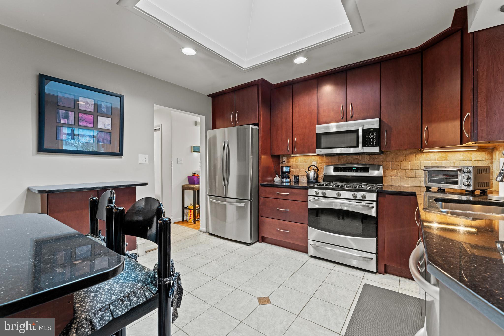 6805 Pamela Lane Clinton, MD 20735 - Photo 9 of 39 a kitchen with stainless steel appliances granite countertop a refrigerator stove microwave and sink