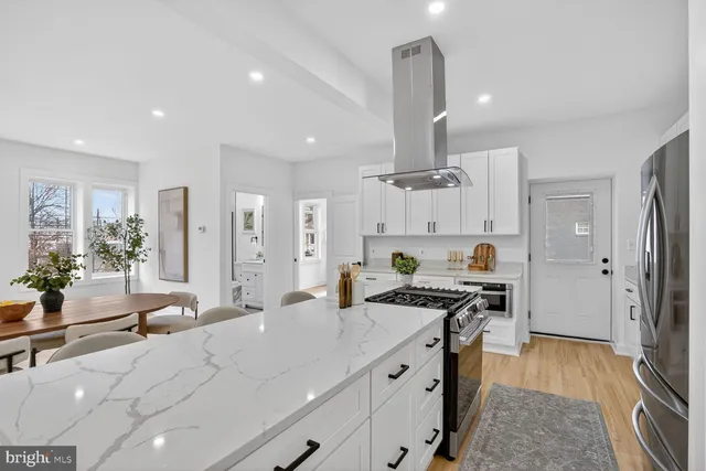 a kitchen with stainless steel appliances a stove a sink a refrigerator and cabinets