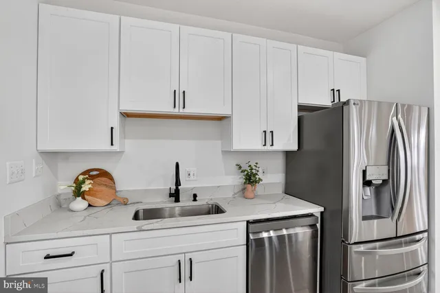 a kitchen with stainless steel appliances a refrigerator a sink and cabinets