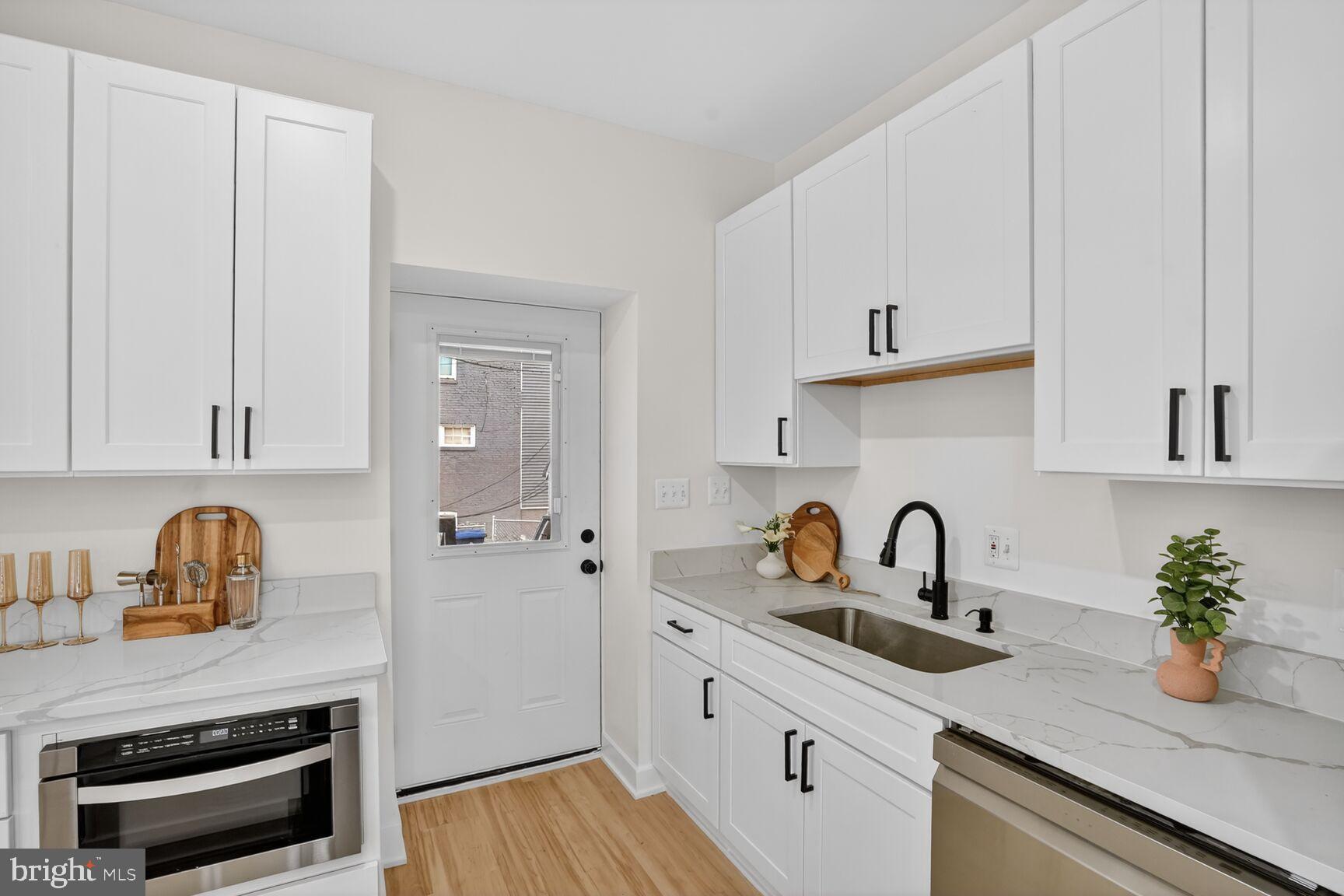 4629 9th Street Northwest Washington, DC 20011 - Photo 14 of 41 a kitchen with appliances a sink a faucet and cabinets