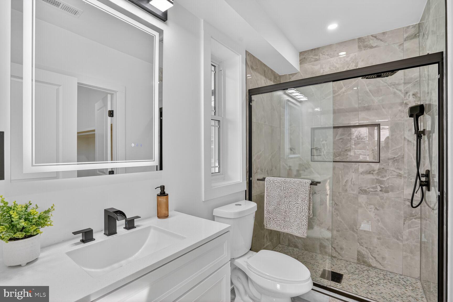 4629 9th Street Northwest Washington, DC 20011 - Photo 30 of 41 a bathroom with a sink toilet a mirror and shower