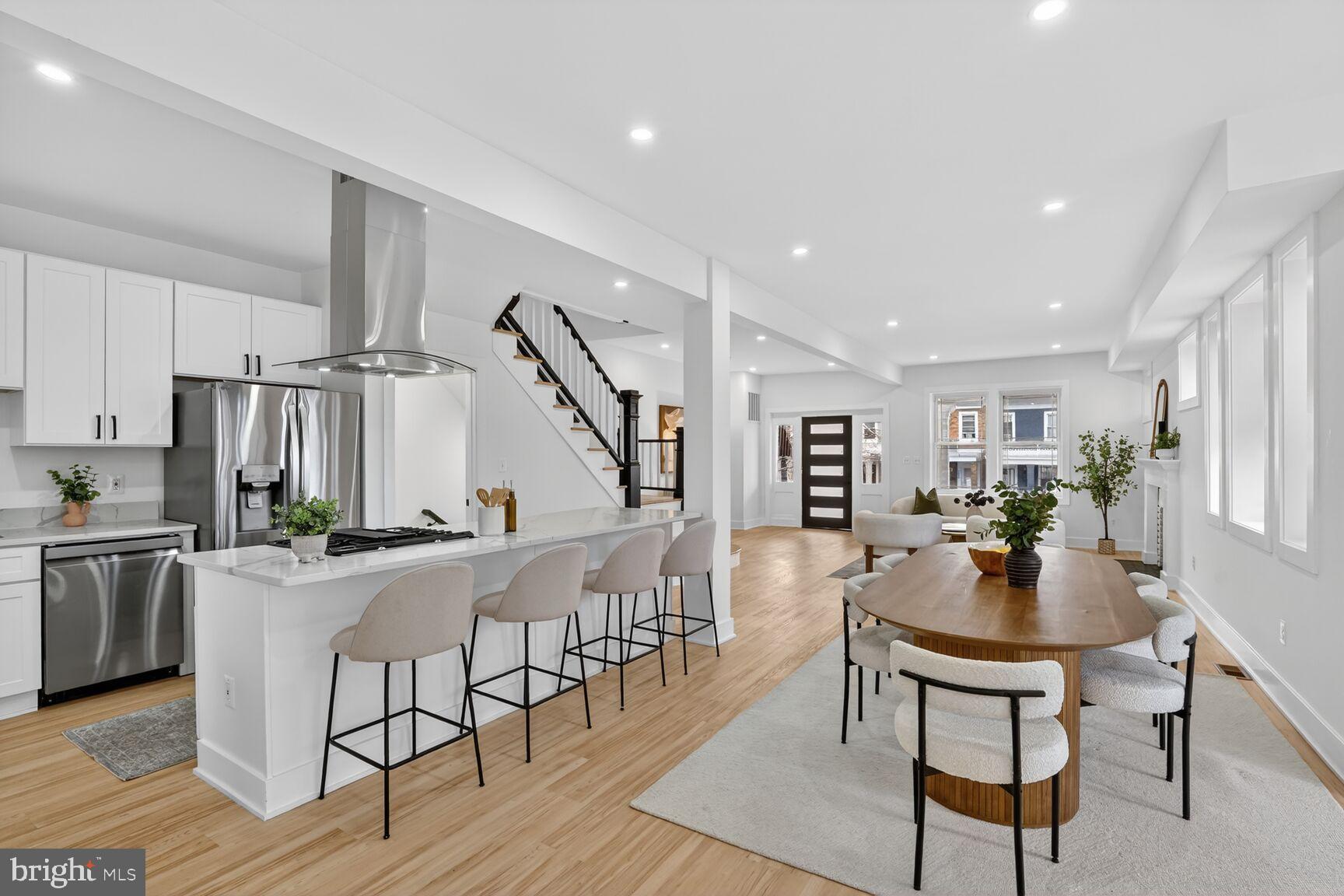 4629 9th Street Northwest Washington, DC 20011 - Photo 8 of 41 a dining room with stainless steel appliances kitchen island granite countertop a dining table chairs and couches with wooden floor