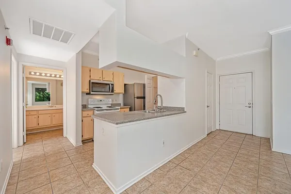 a kitchen with stainless steel appliances granite countertop a sink a stove top oven and a refrigerator