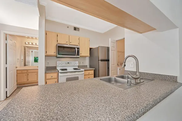 a kitchen with granite countertop cabinets stainless steel appliances and a counter space