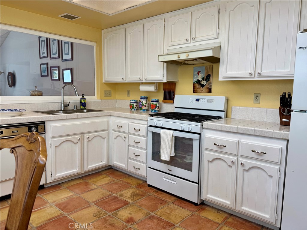 8 Coldstream Irvine, CA 92604 - Photo 10 of 27 a kitchen with white cabinets stainless steel appliances and sink