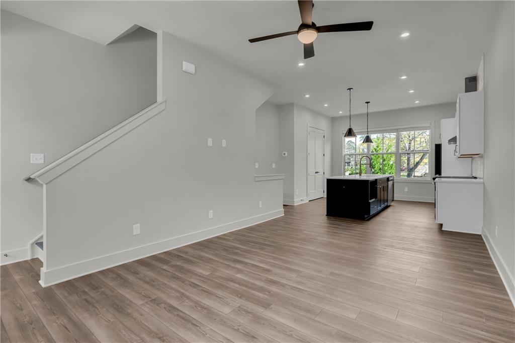 152 Chestnut Circle Atlanta, GA 30342 - Photo 18 of 53 an empty room with wooden floor a ceiling fan and windows