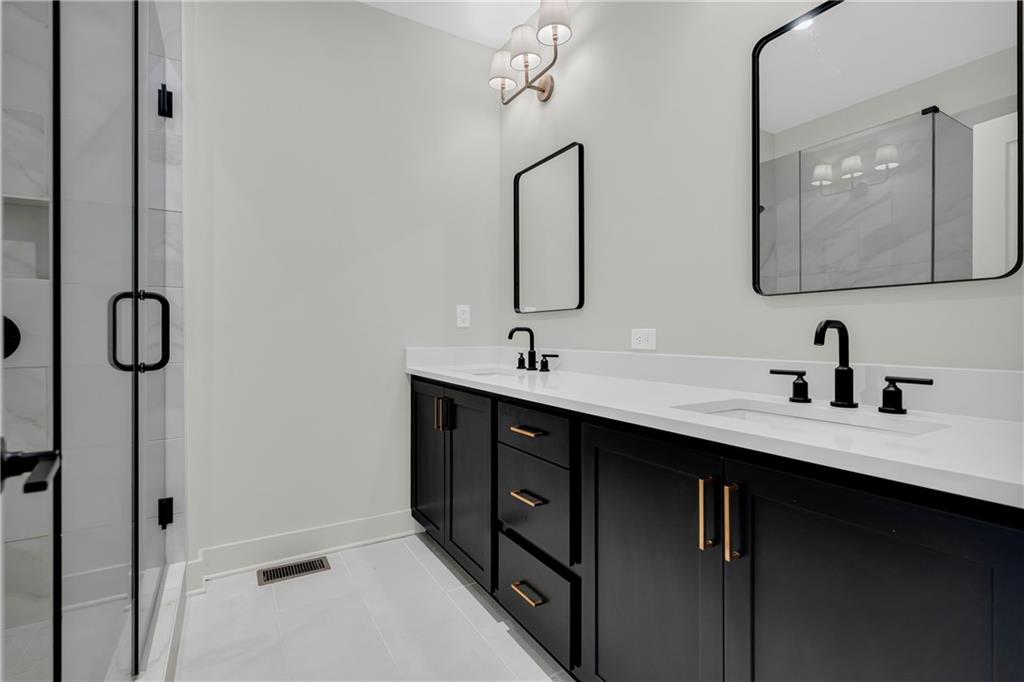 152 Chestnut Circle Atlanta, GA 30342 - Photo 35 of 53 a bathroom with a double vanity sink a mirror and shower