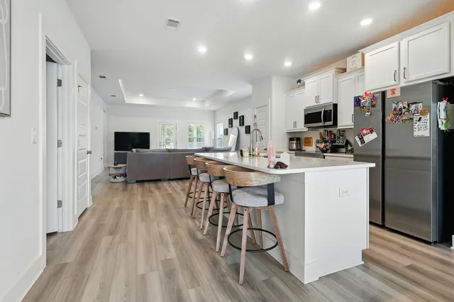 a kitchen with stainless steel appliances a refrigerator a stove a sink dishwasher and a oven with wooden floor