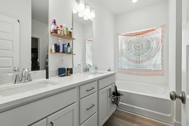 a bathroom with a tub sink and mirror