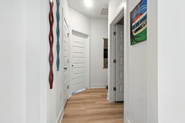 a view of a hallway with wooden floor and staircase