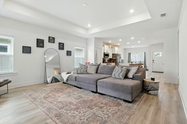 a living room with furniture and a wooden floor