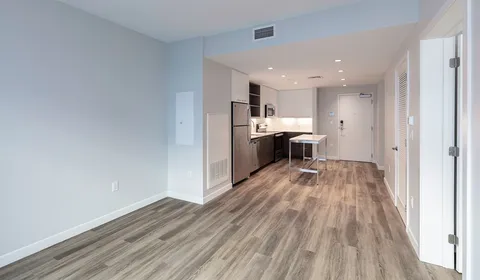 a view of a kitchen with wooden floor and electronic appliances