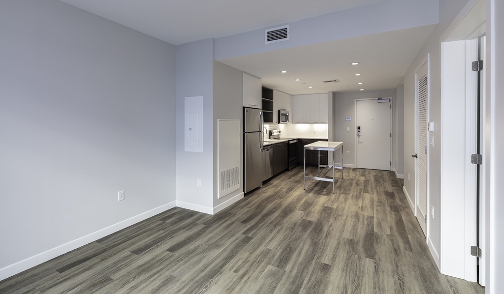 a view of a kitchen with wooden floor and electronic appliances