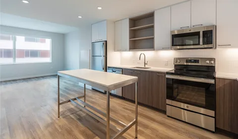 a kitchen with stainless steel appliances kitchen island a stove a sink and a microwave