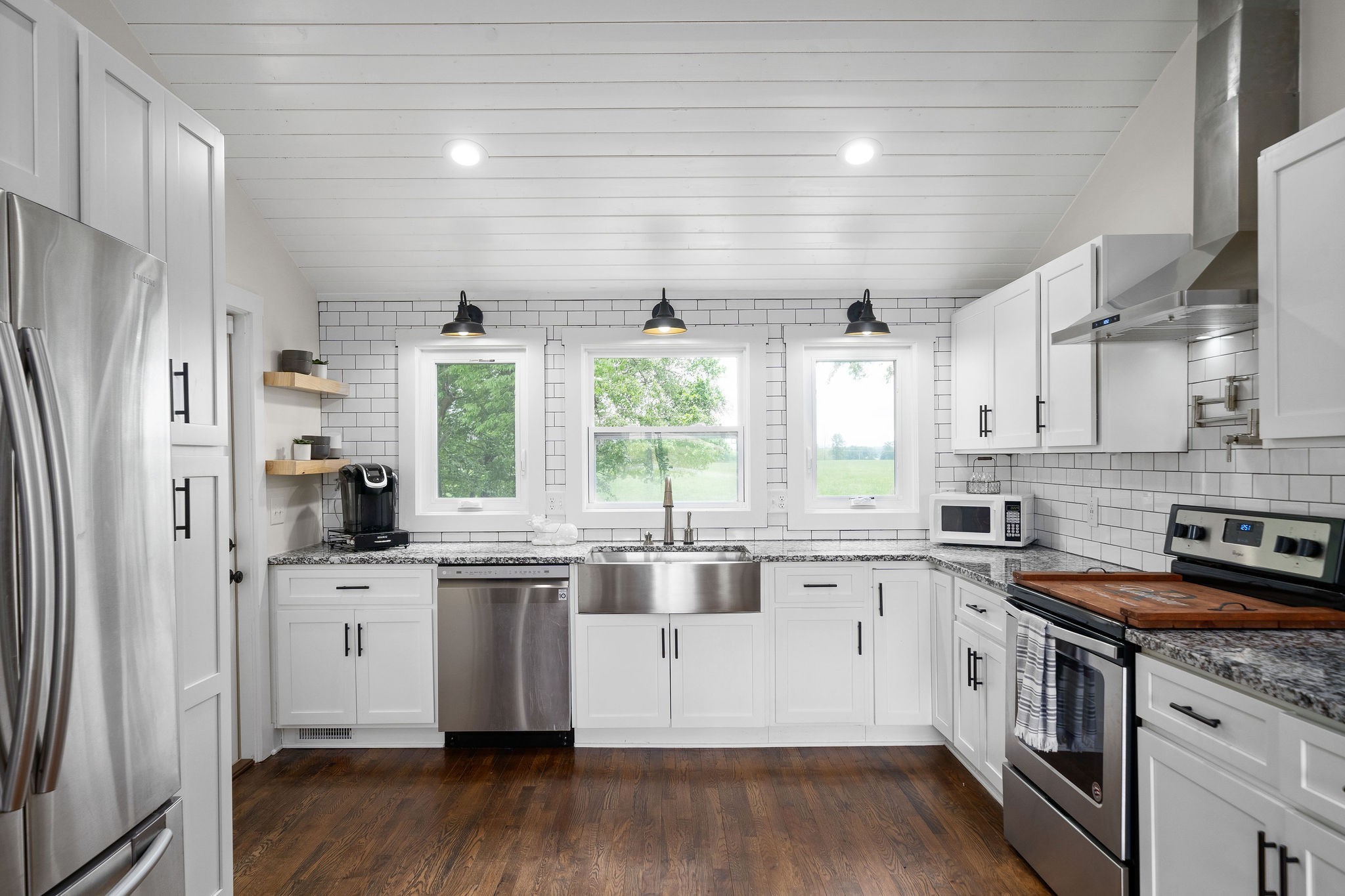 3612 Rossview Road Adams, TN 37010 - Photo 11 of 41 a kitchen with stainless steel appliances a white cabinets and wooden floors