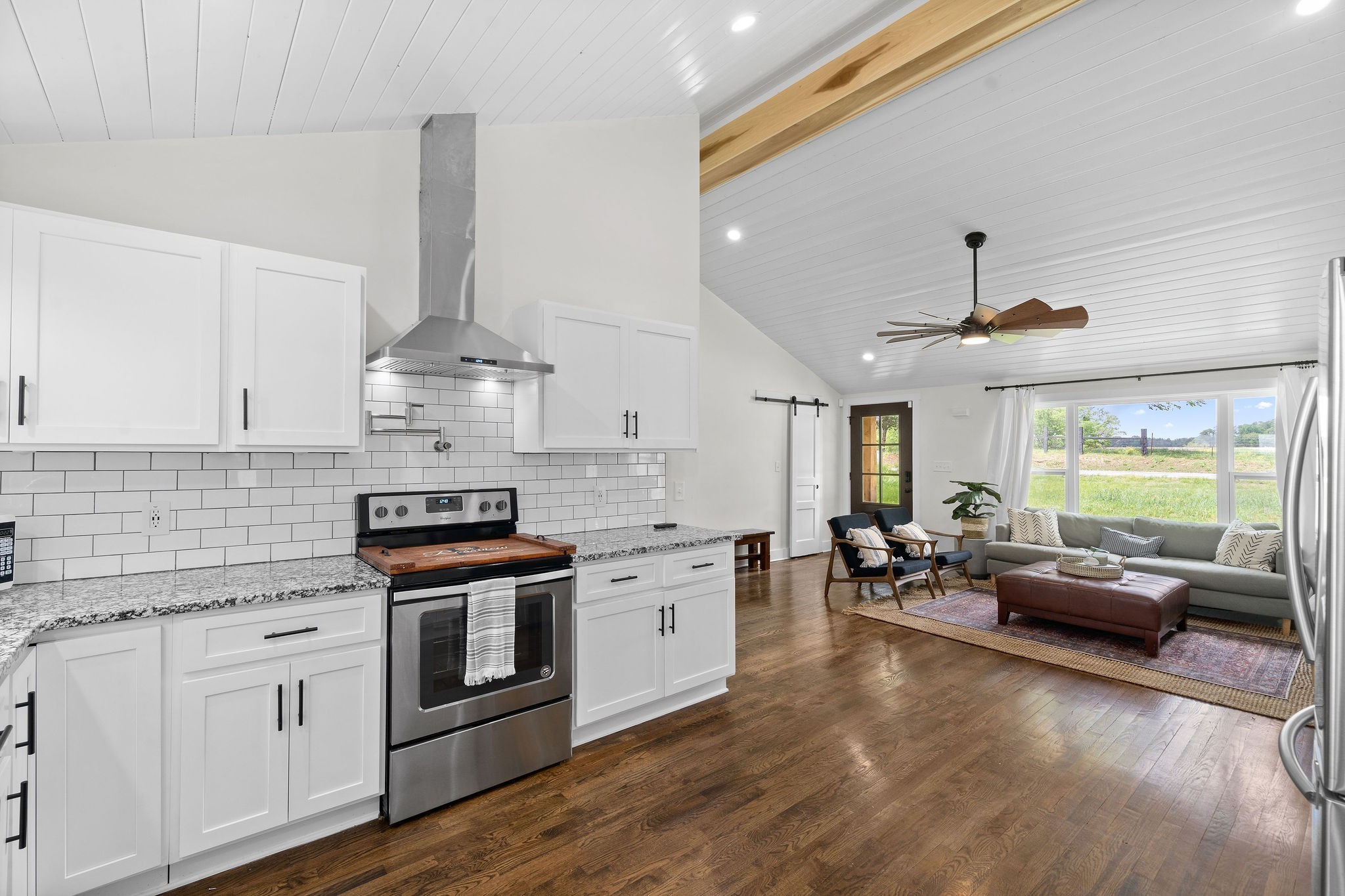 3612 Rossview Road Adams, TN 37010 - Photo 14 of 41 a kitchen with stainless steel appliances white cabinets a stove a sink and a large window
