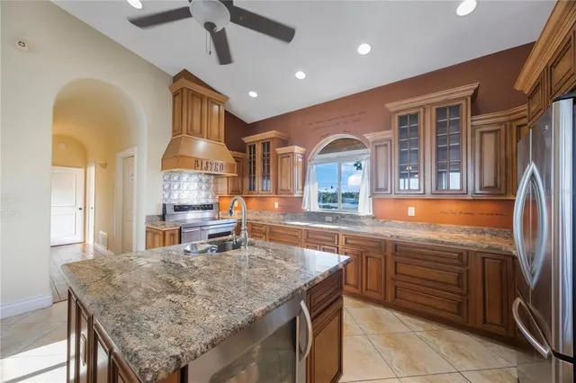 a kitchen with stainless steel appliances granite countertop a sink stove and refrigerator