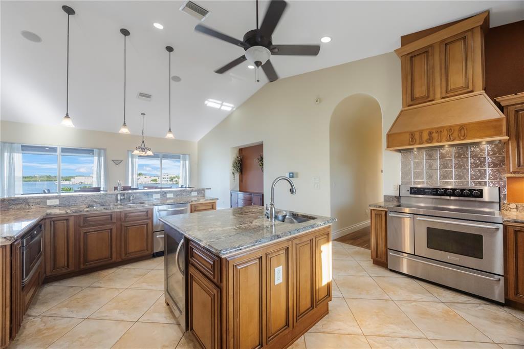 736 Pruitt Drive Madeira Beach, FL 33708 - Photo 15 of 42 a kitchen with stainless steel appliances granite countertop a sink a stove and a refrigerator