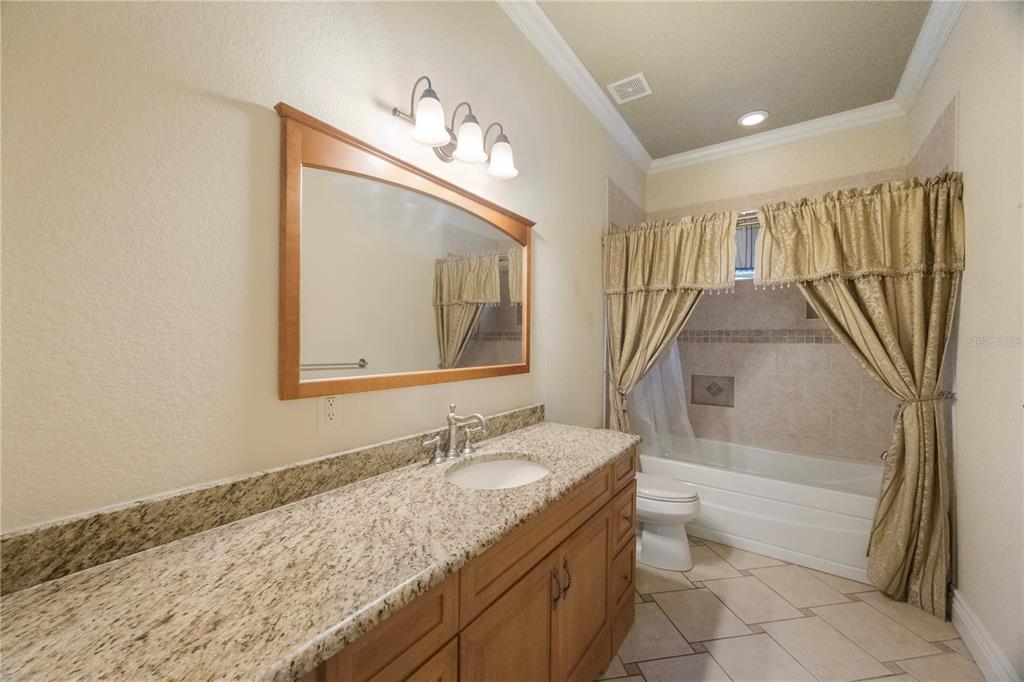736 Pruitt Drive Madeira Beach, FL 33708 - Photo 20 of 42 a bathroom with a granite countertop sink a mirror and a bathtub