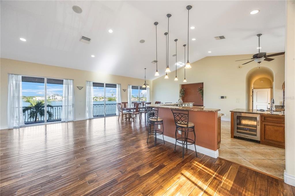 736 Pruitt Drive Madeira Beach, FL 33708 - Photo 6 of 42 a view of kitchen with stainless steel appliances granite countertop a stove top oven a sink a dining table and chairs with wooden floor