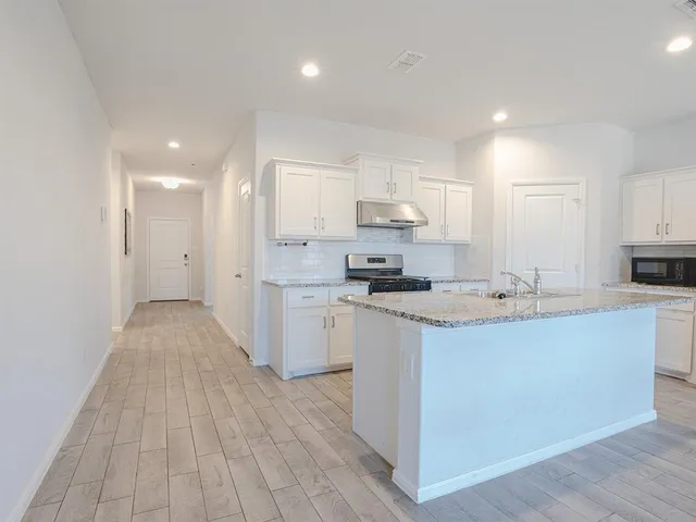a kitchen with stainless steel appliances a sink stove and cabinets