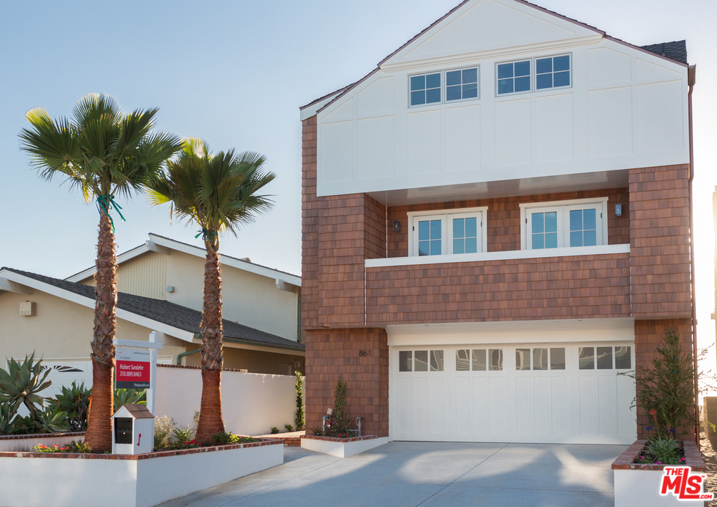 861 Mandalay Beach Road Oxnard, CA 93035 - Photo 3 of 31 a front view of a house with a yard and garage