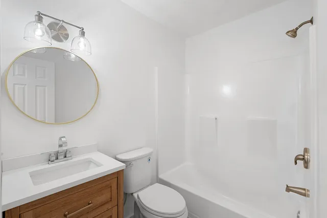 a bathroom with a sink a toilet and a mirror