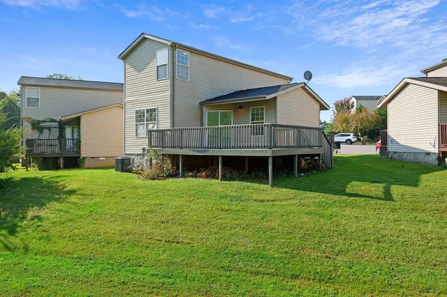 a view of a big house with a big yard and large trees