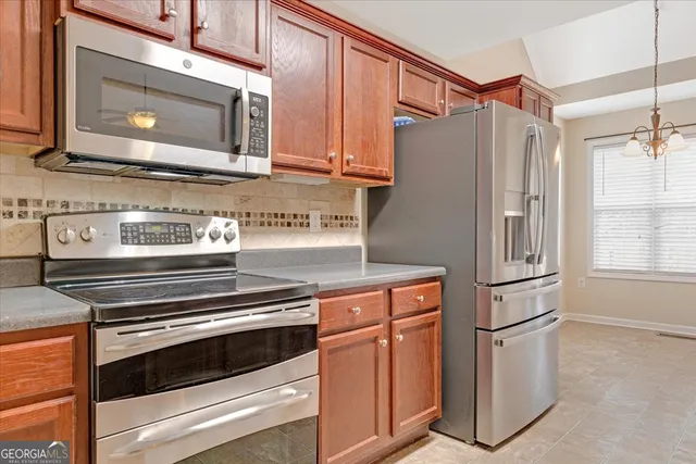 a kitchen with stainless steel appliances white cabinets and a stove top oven