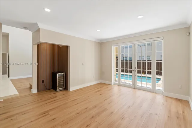 a view of empty room with wooden floor and floor to ceiling window
