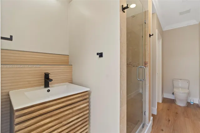 a bathroom with a sink a toilet and shower