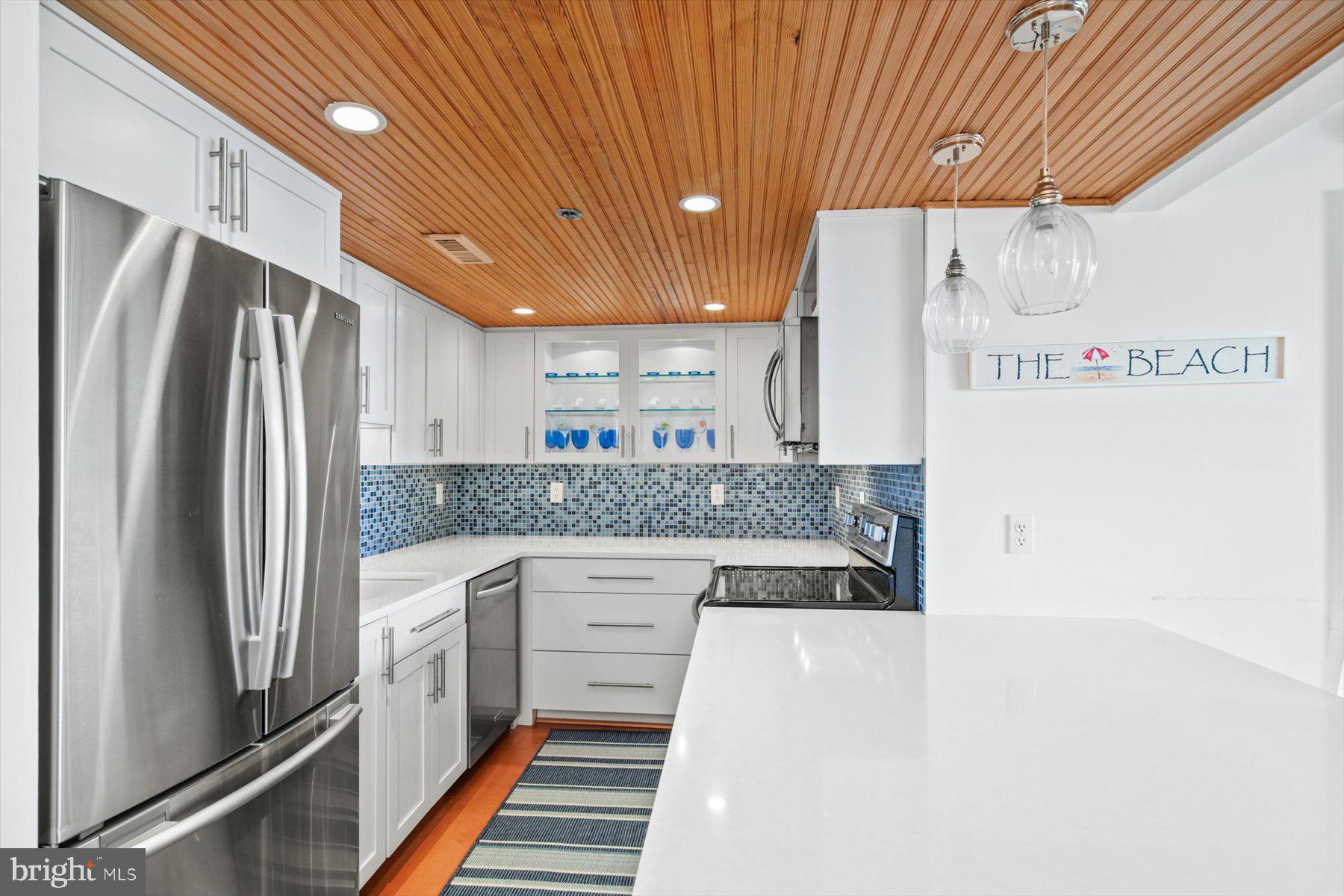 312 Island House Road Bethany Beach, DE 19930 - Photo 16 of 48 a kitchen with stainless steel appliances a refrigerator and a stove
