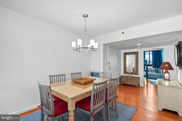 a view of a dining room with furniture a chandelier and large windows