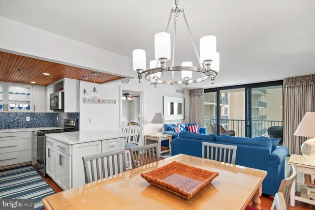 a view of a dining room with furniture a chandelier and wooden floor