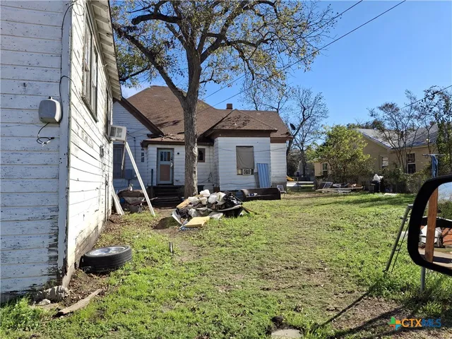 a view of a house with backyard and sitting area