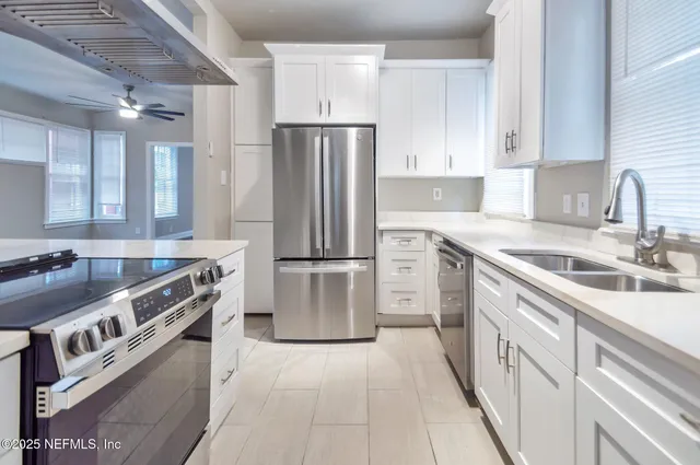 a kitchen with stainless steel appliances granite countertop a sink stove and refrigerator