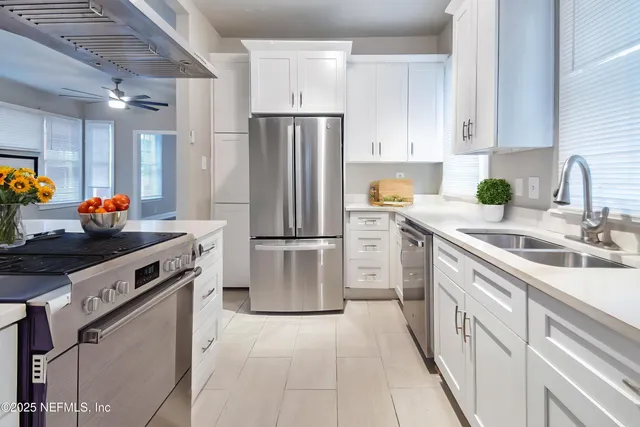a kitchen with white cabinets and stainless steel appliances