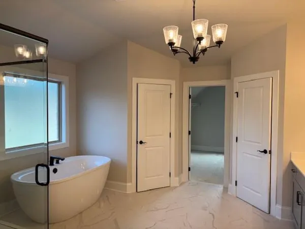 a spacious bathroom with a granite countertop tub and a mirror