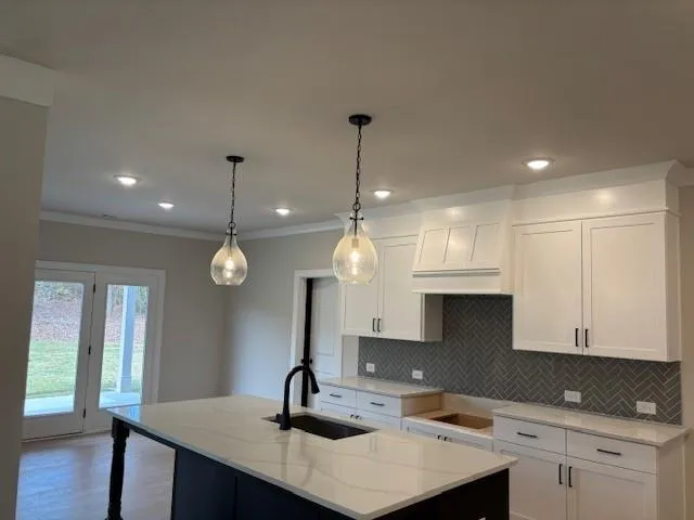 a kitchen with kitchen island granite countertop a sink a counter space and cabinets