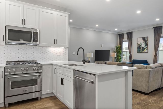 a kitchen with stainless steel appliances a stove microwave and sink