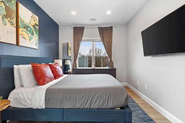 a bedroom with a large bed and a flat screen tv