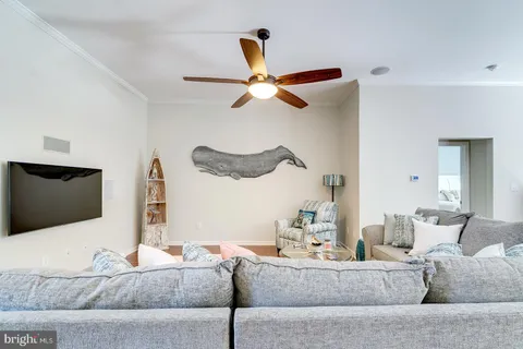 a living room with furniture and a ceiling fan