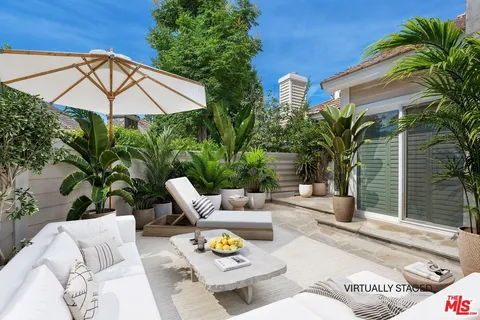 a view of a patio with couches and potted plants