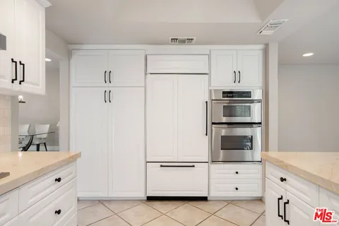 a kitchen with white cabinets and white appliances