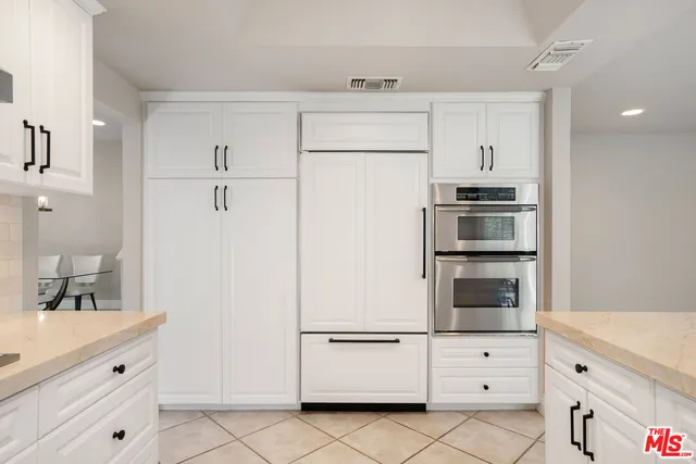 a kitchen with white cabinets and white appliances