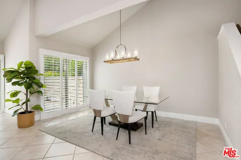 a dining room with furniture and a potted plant