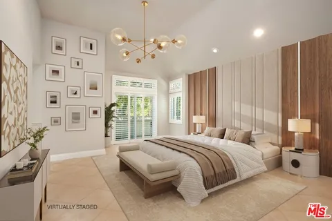 a spacious bedroom with a large bed and a chandelier